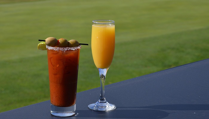 A Bloody Mary and mimosa await on the outdoor table—Breakfast & Brunch Menu at Cosmic Golf.